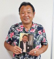 このほど上梓した書籍を手に笑顔を見せる古知屋さん＝８月、ハピネス茅ヶ崎