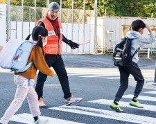 横断歩道を渡る児童を誘導する｢今井小学校学援隊｣の細川隊長