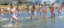 掛け声とともに多摩川の水を全身に浴びるメンバー