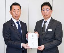 倉田専務理事事務局長（右）に救援金を手渡す有井会長