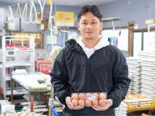 鶏卵を手にする３代目の大矢忠慶さん
