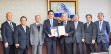 高橋市長に岩崎会長（中央右）が目録を手渡した