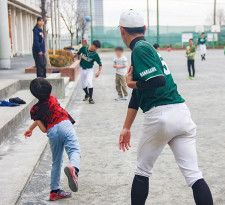 小学生に投球フォームを指導する高校生たち