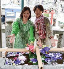 大きい方の手水鉢を前に小和口さん（左）と内田さん。２人の店が鳥居の左右にあることから「狛犬レディ」と名乗っている