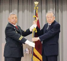 団旗を手にする村上団長（左）と小松原前団長