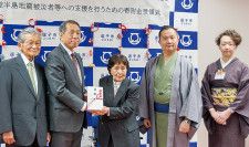 桐ケ谷市長（左から2番目）に寄付金を渡す五味川さん（中央）