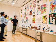 ギャラリーに展示された生徒の作品について説明する石原健一郎さん（右）