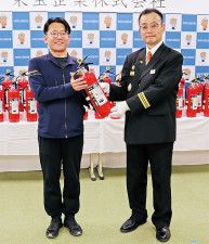 消火器を持つ前田代表（左）と福田団長