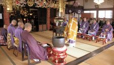 中央に立ち経を唱える常照寺の川腰住職と、向き合って座る僧侶ら