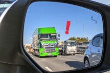 高速道路での渋滞で、後ろから迫る大型トラックのイメージ（画像：写真AC）。