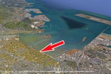奥が北九州空港。周防灘沿いの「恒見朽網線」（矢印）が一部開通する（画像：Google earth）。