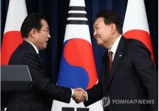 首脳会談後の共同会見で握手を交わす韓日首脳＝7日、ソウル（聯合ニュース）