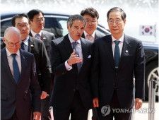 国連の施設が集まるウィーン国際センターに到着し、グロッシ事務局長に案内される韓首相（右）＝9日、ウィーン（聯合ニュース）