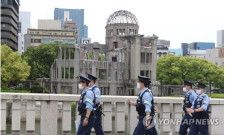 G7サミットの開幕を翌日に控えた広島市内は警戒態勢が敷かれている。原爆ドームの近くで警戒に当たる警察＝18日、広島（聯合ニュース）