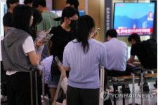 31日午前、ソウル駅で警戒警報を確認する人たち＝（聯合ニュース）