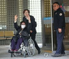 控訴審判決に両腕を上げて喜びを示す李容洙さん＝２３日、ソウル（聯合ニュース）