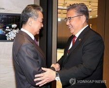 韓国の朴振（パク・ジン）外交部長官（右）は２６日、釜山市内のホテルで中国の王毅共産党政治局員兼外相と会談した。握手を交わす両氏＝（聯合ニュース）