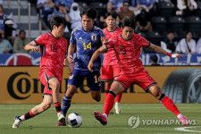 日本選手を囲む赤いユニホームの韓国の選手＝（聯合ニュース）