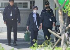 仮釈放されて拘置所を出るチェ氏＝１４日、ソウル（聯合ニュース）