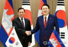 ソウルの大統領室庁舎で握手を交わす韓国の尹錫悦大統領（右）とカンボジアのフン・マネット首相（大統領室通信写真記者団）＝１６日、ソウル（聯合ニュース）