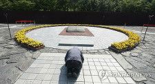 盧武鉉元大統領の墓前で頭を下げる市民＝２３日、金海（聯合ニュース）