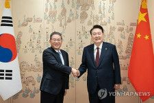 会談で握手を交わす韓国の尹錫悦大統領（右）と中国の李強首相（大統領室提供）＝２６日、ソウル（聯合ニュース）